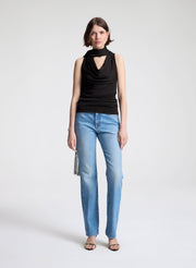 woman wearing dark brown draped top and  light blue denim straight leg jeans