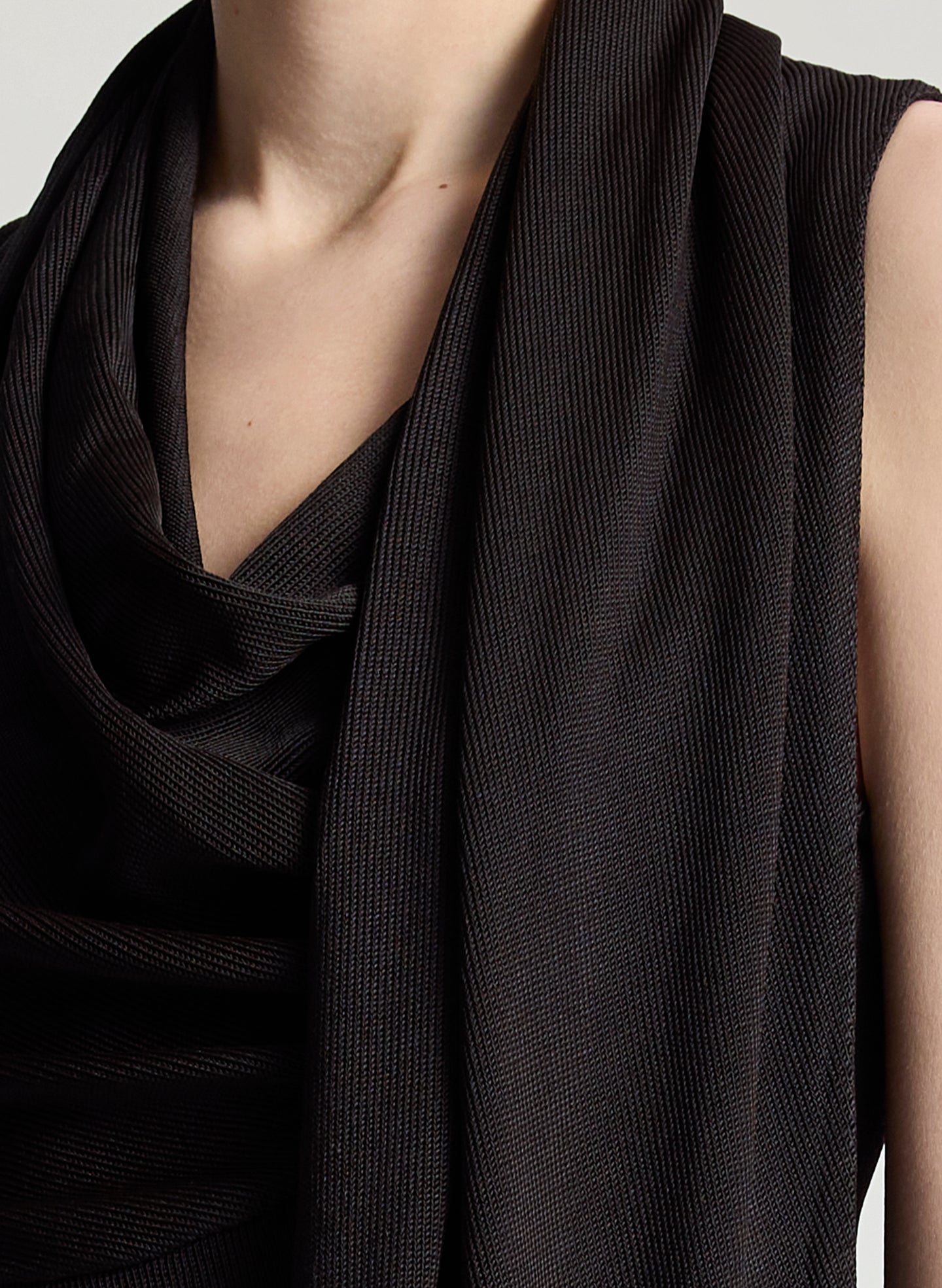 woman wearing dark brown draped top and  light blue denim straight leg jeans