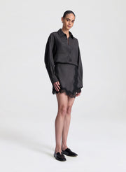 woman wearing brown and black shirt with matching lace trimmed mini skirt