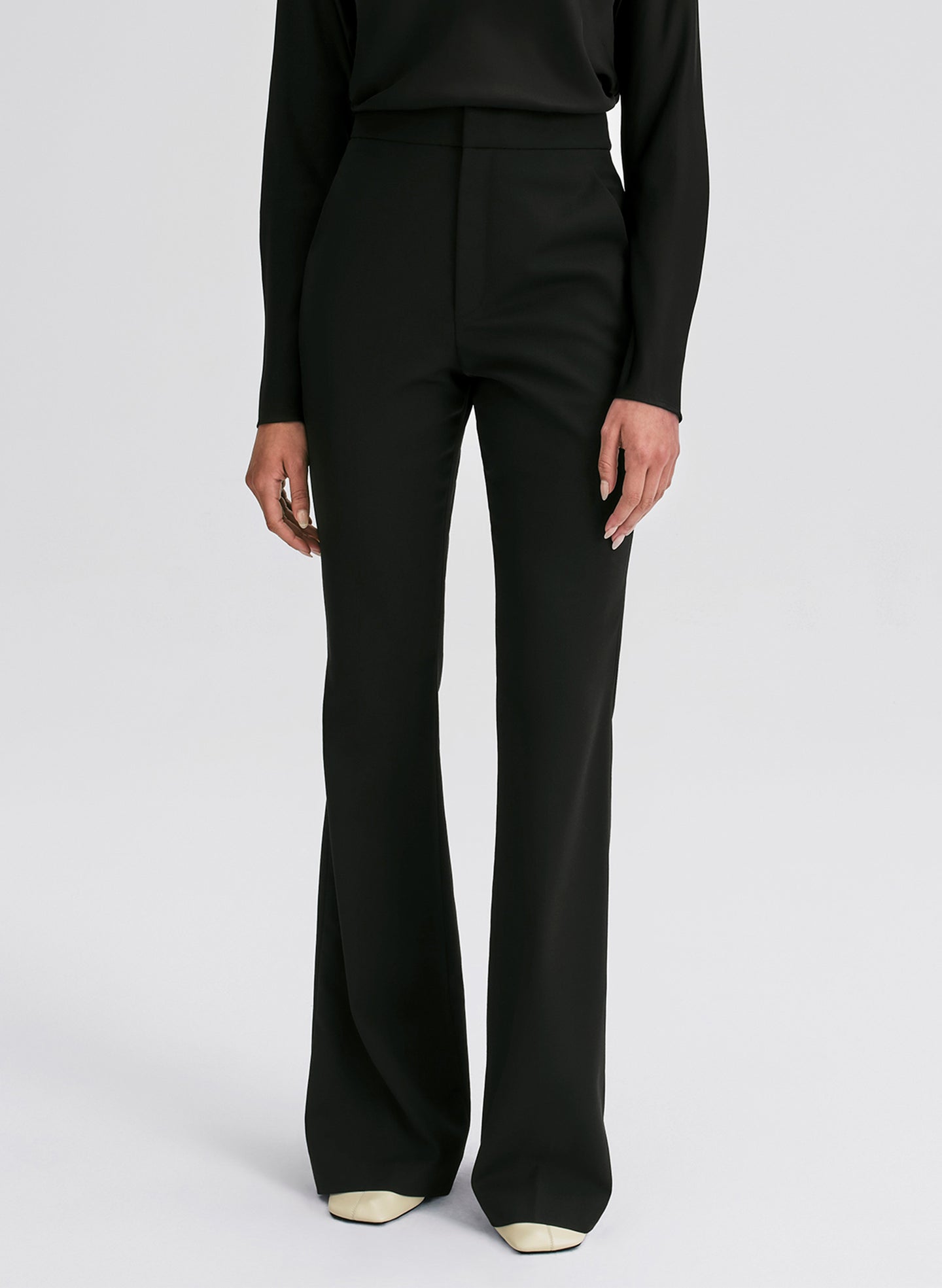 Black pants worn by a person on a white background