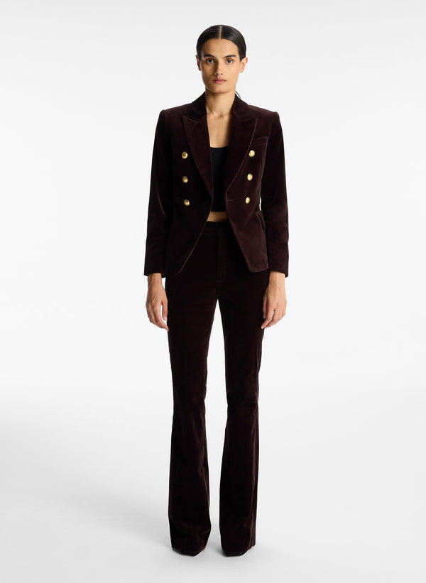 front view of woman wearing brown velvet jacket with gold buttons and brown velvet flared pants