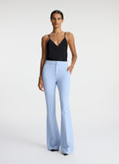 front view of woman wearing black satin camisole with light blue pants