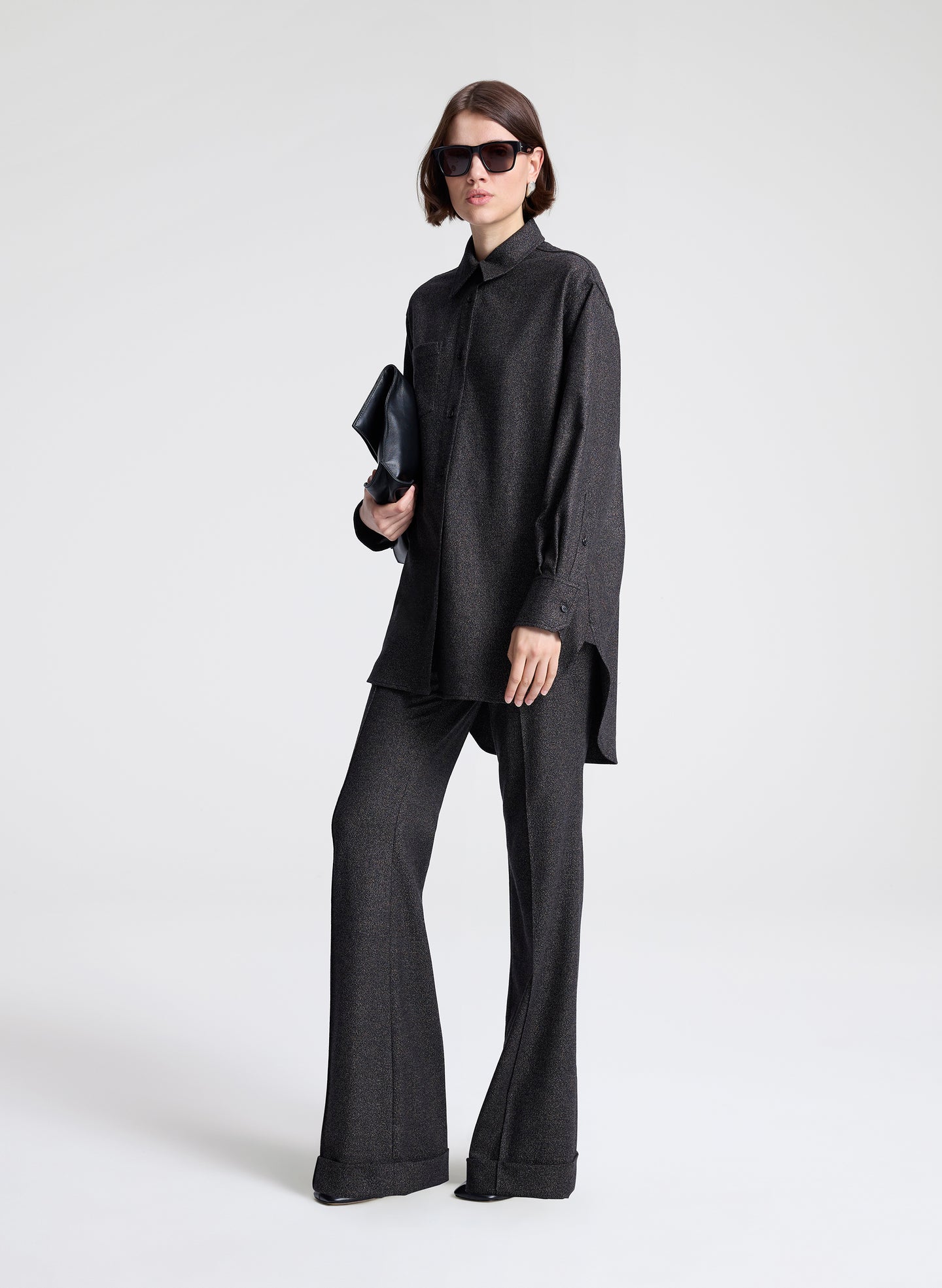 Person wearing a black outfit with wide-leg pants on a white background