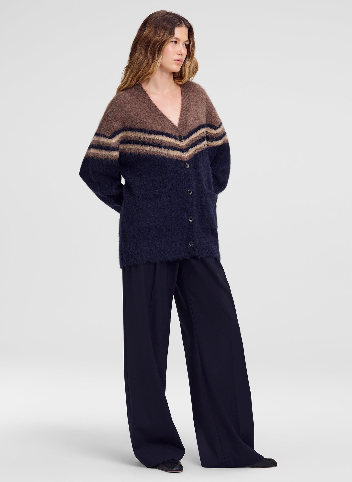 woman in brown and navy cardigan with blue pants