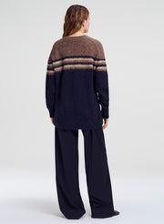 woman in brown and blue cardigan with navy pants