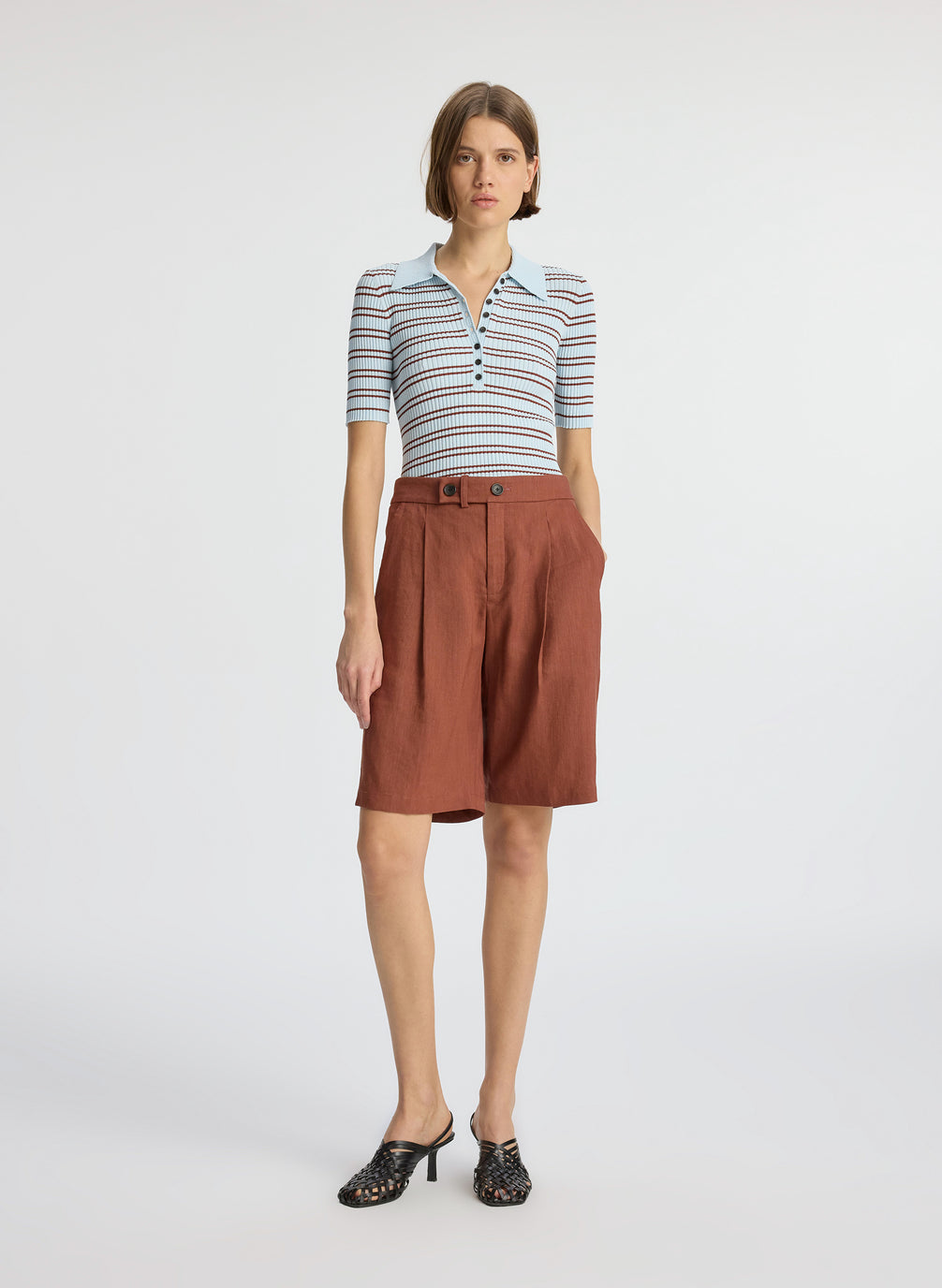 front view of woman wearing blue and brown striped shirt and brown shorts