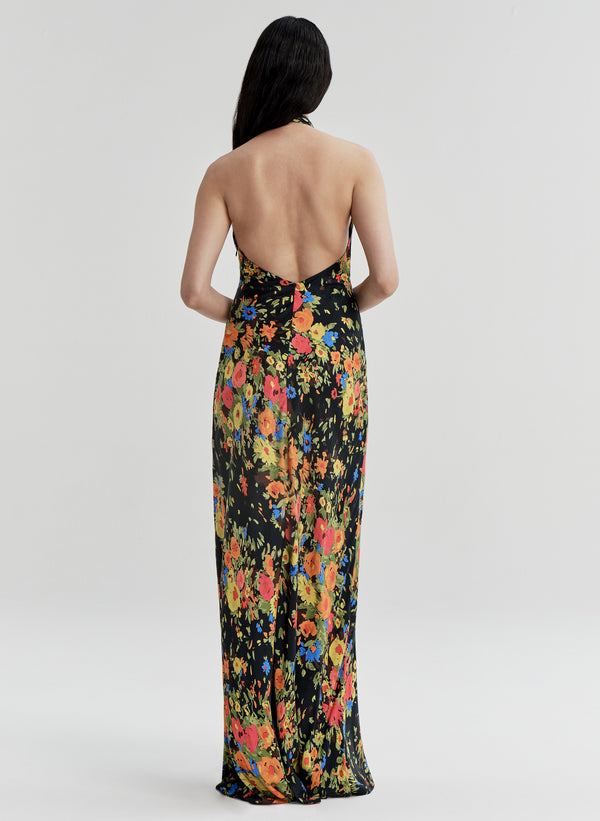 Woman wearing a floral gown with an open back on a white background