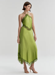Woman wearing a green dress with lace details on a white background