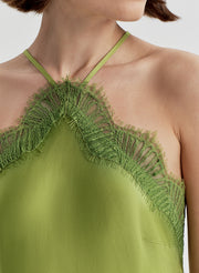 Green dress with lace detailing on a neutral background