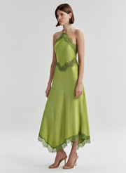 Woman wearing a green dress with lace details on a white background