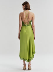 Woman wearing a green dress with a lace detail on a white background