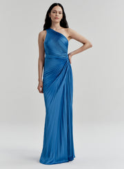 Woman wearing a blue pleated one-shoulder gown against a white background