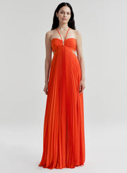 Woman wearing a bright orange halter neck gown on a white background