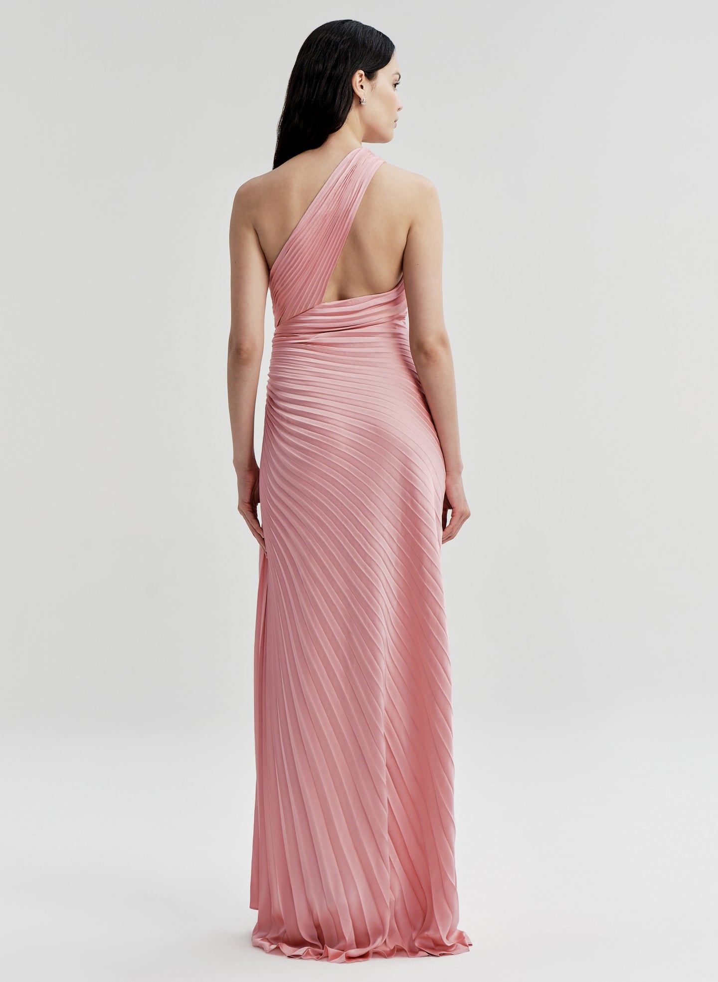 Woman wearing a pink pleated gown on a white background