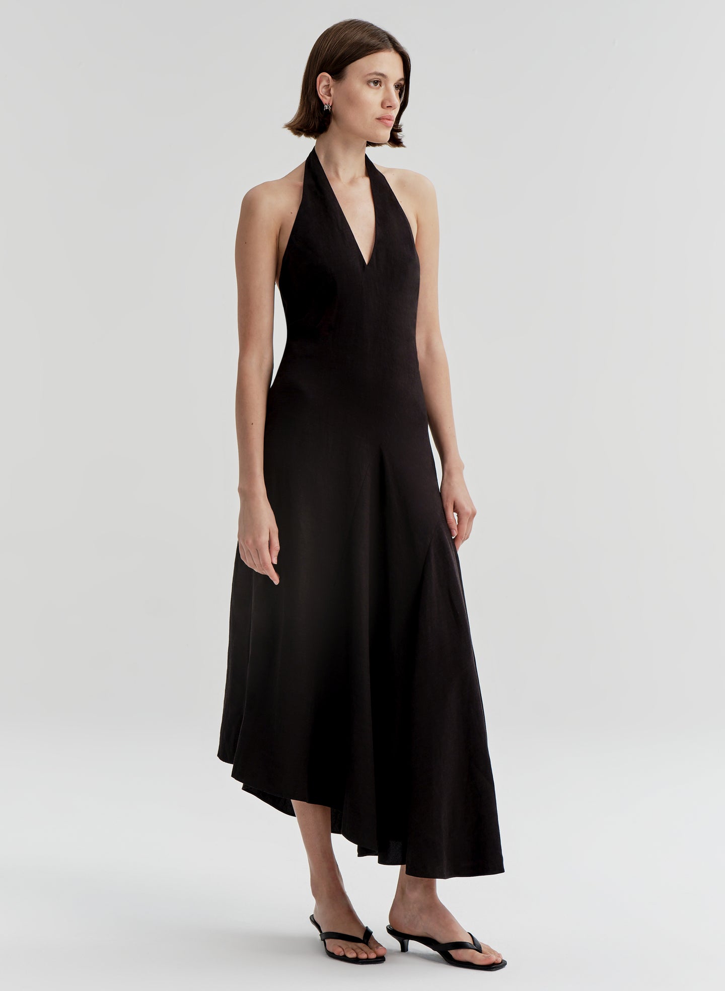 Woman wearing a black halter neck dress on a white background