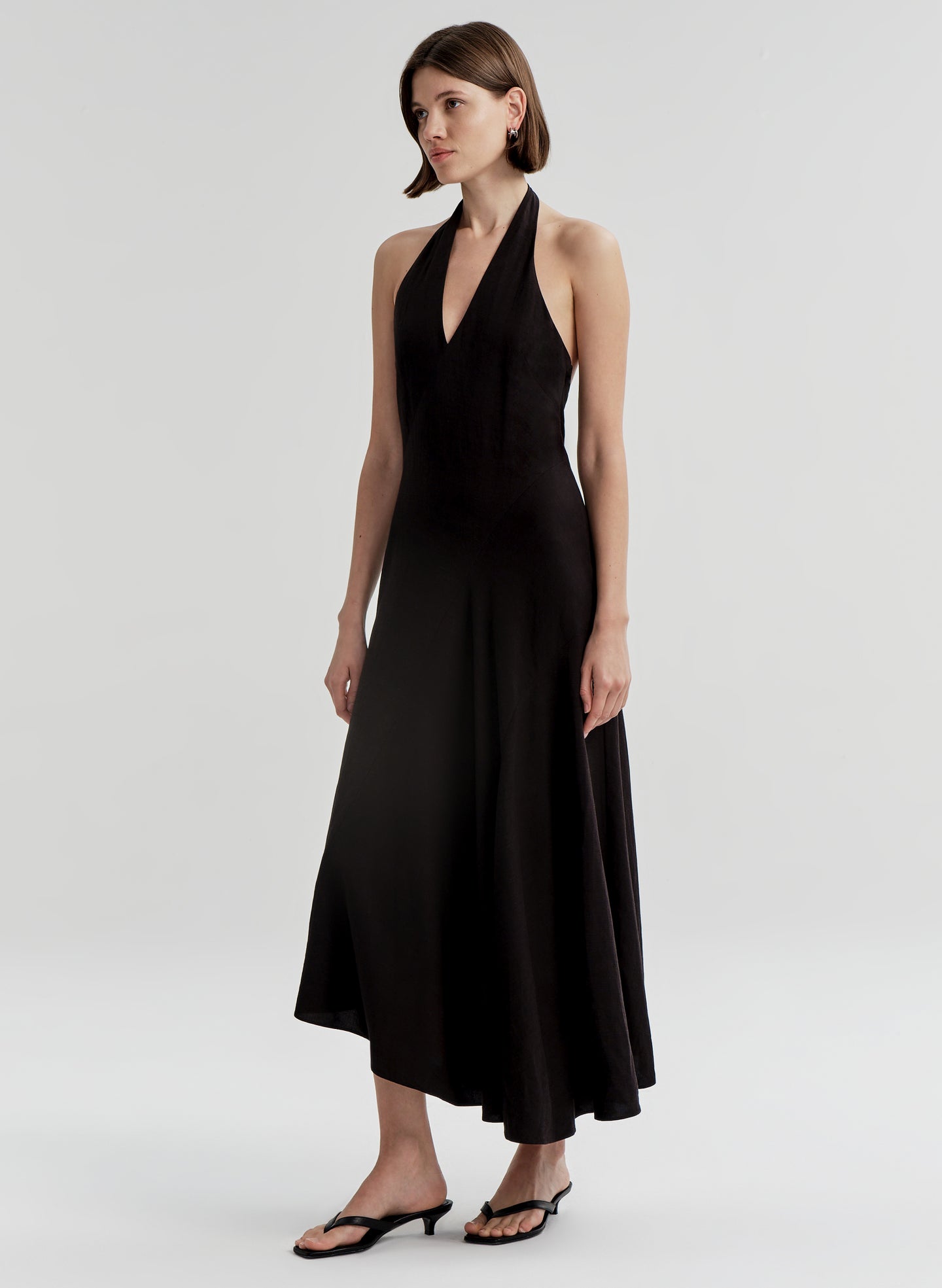 Woman wearing a black halter neck dress on a white background