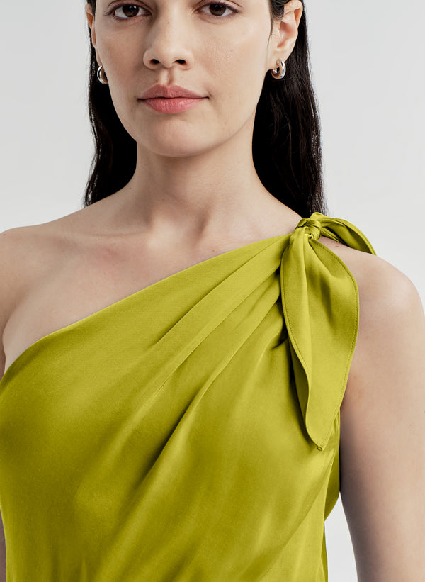 Woman wearing a green one-shoulder dress on a white background