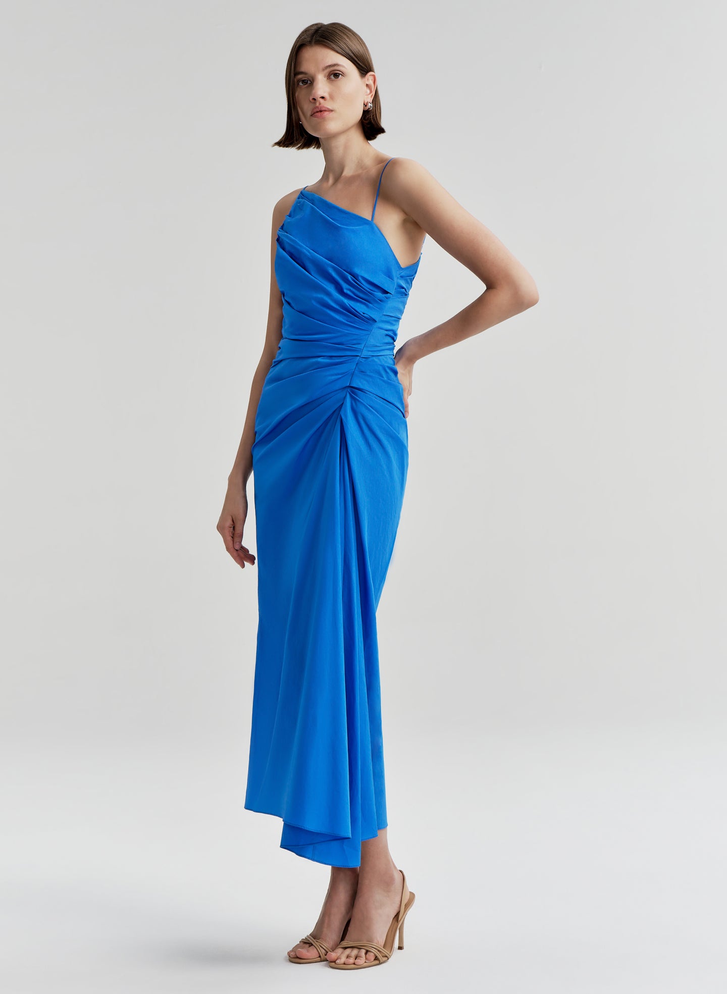 Woman wearing a blue midi dress on a light gray background