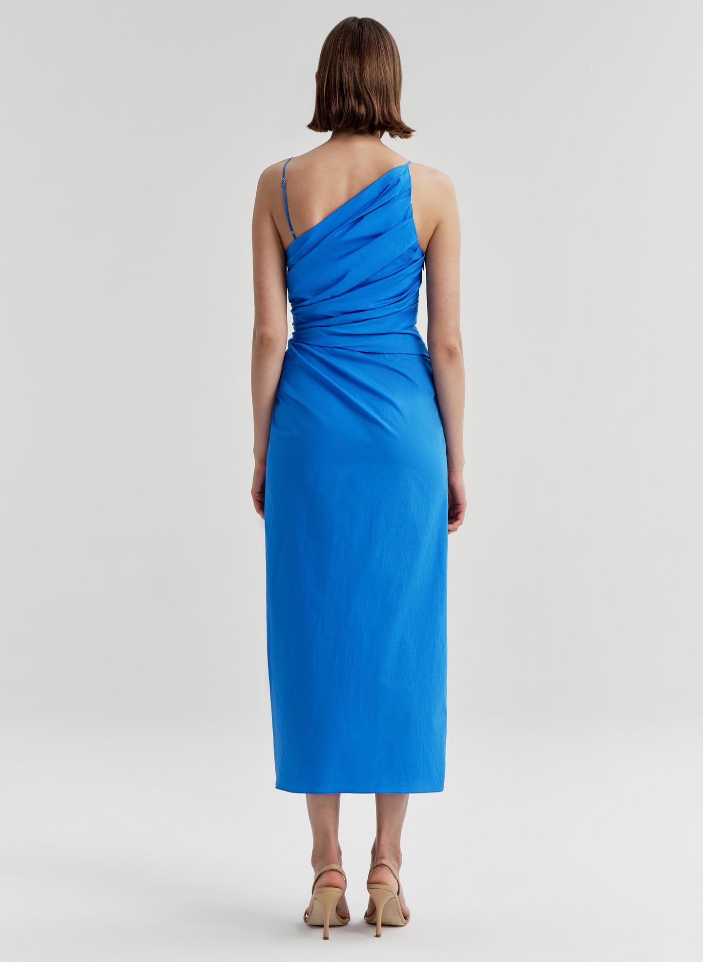 Woman wearing a blue midi dress on a light gray background