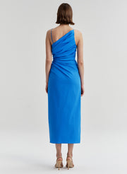 Woman wearing a blue midi dress on a light gray background