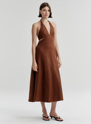 Woman wearing a brown halter neck dress on a white background