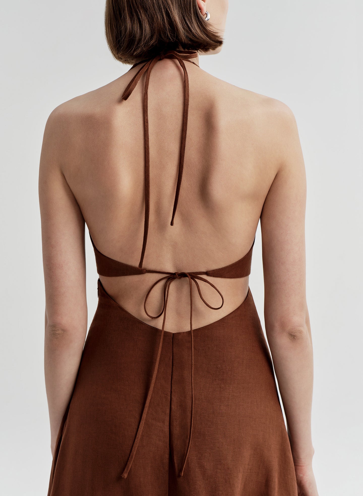 Brown dress with open back on a white background