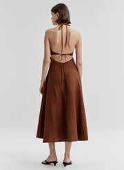 Woman wearing a brown dress with open back on a white background