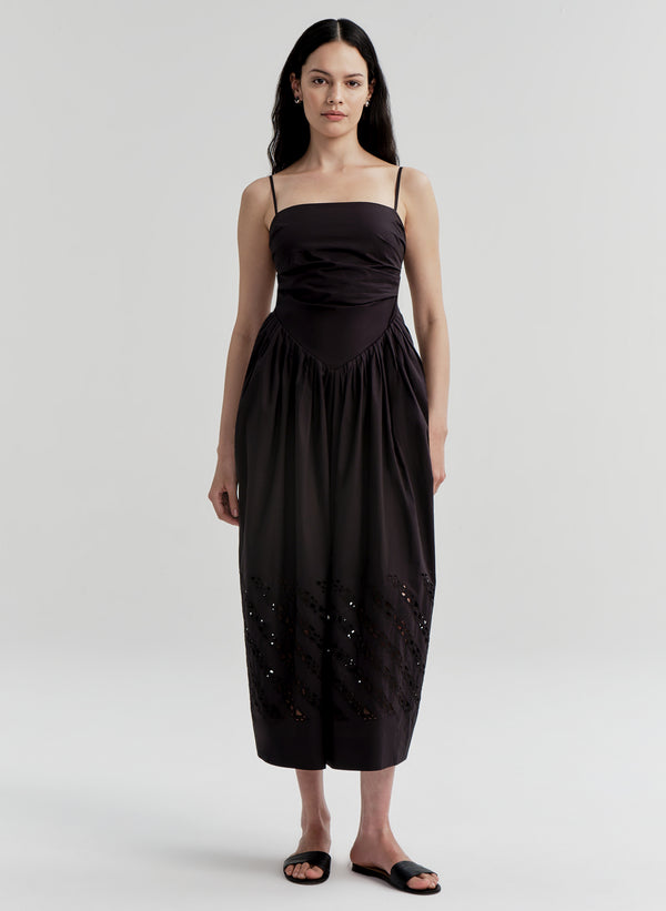 Woman wearing a black dress with cut-out details on a white background