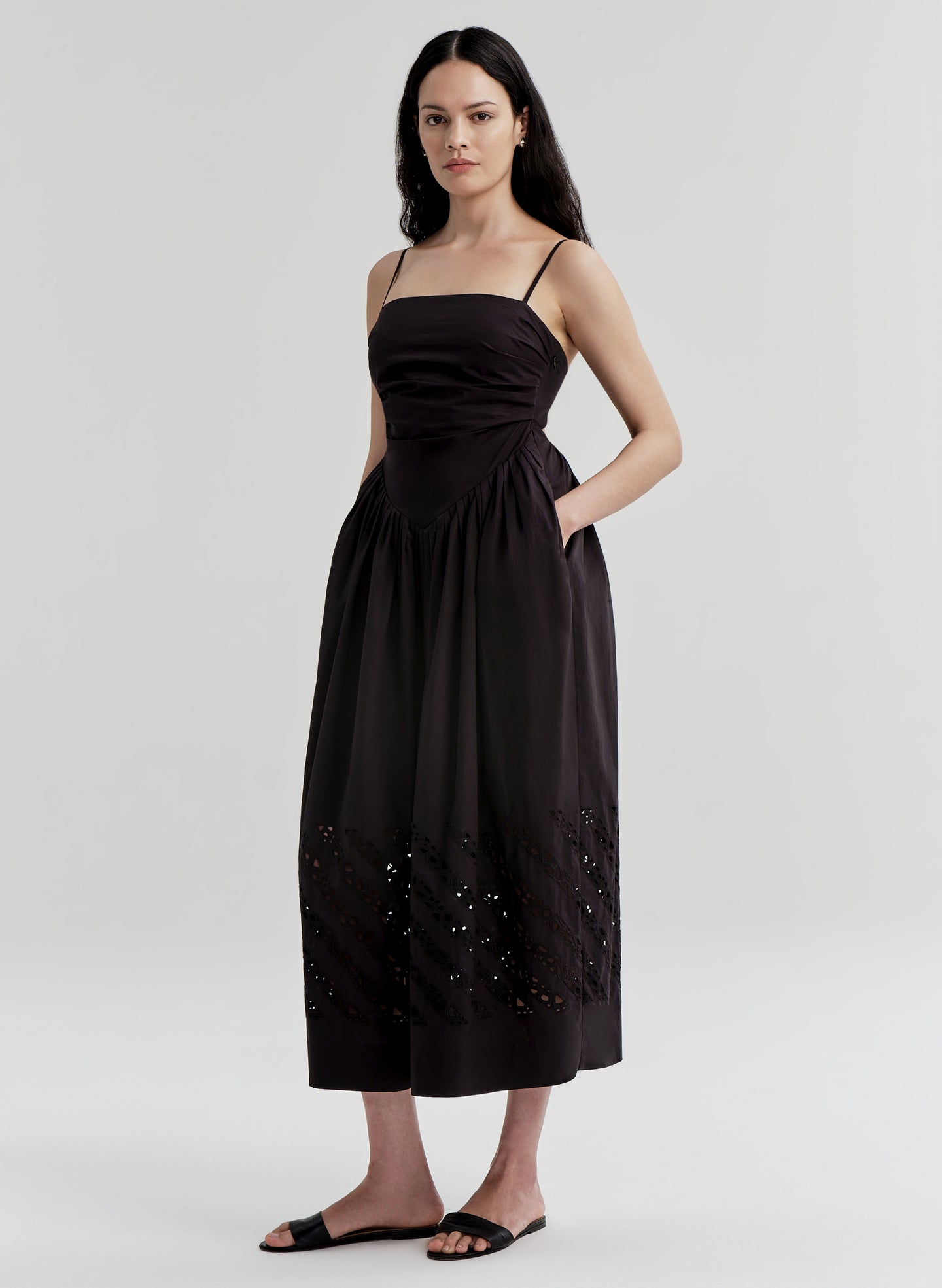 Woman wearing a black dress with cut-out details on a white background