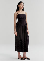 Woman wearing a black dress with cut-out details on a white background