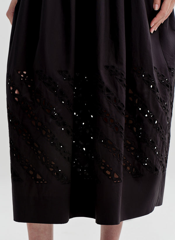 Woman wearing a black dress with cut-out details on a white background