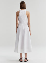 Woman wearing a white sleeveless dress on a plain background