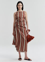 Woman wearing a linen brown and beige striped dress on a white background