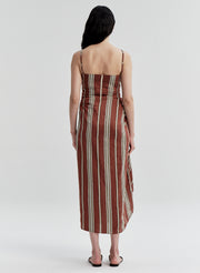 Woman wearing a linen brown and beige striped dress on a white background