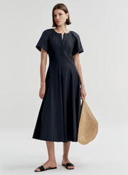 Woman wearing a dark blue short sleeve dress on a white background