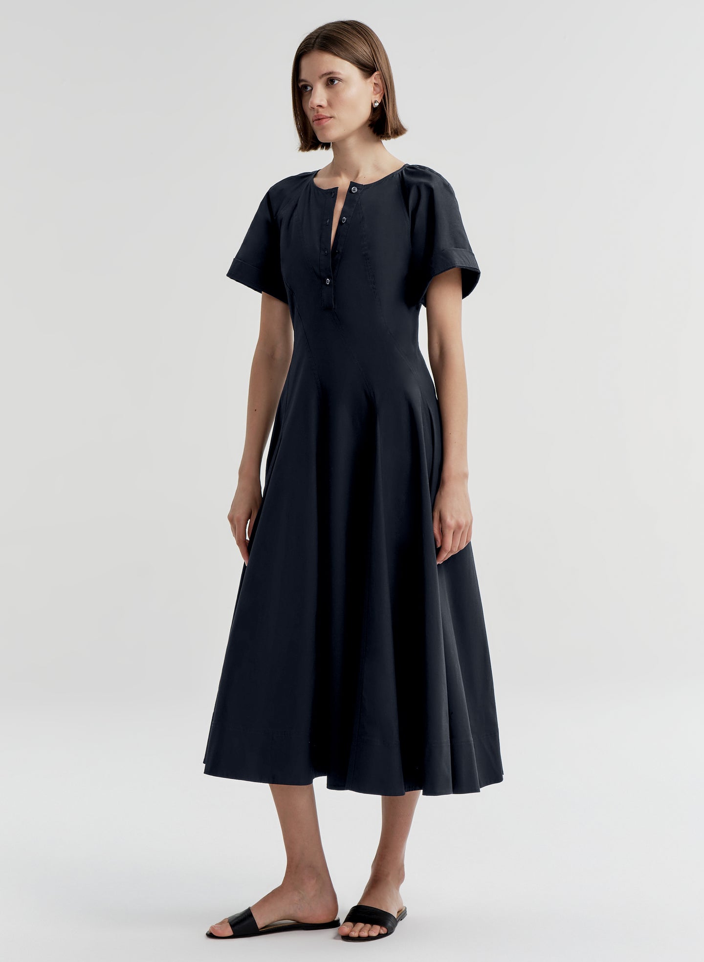 Woman wearing a dark blue short sleeve dress on a white background