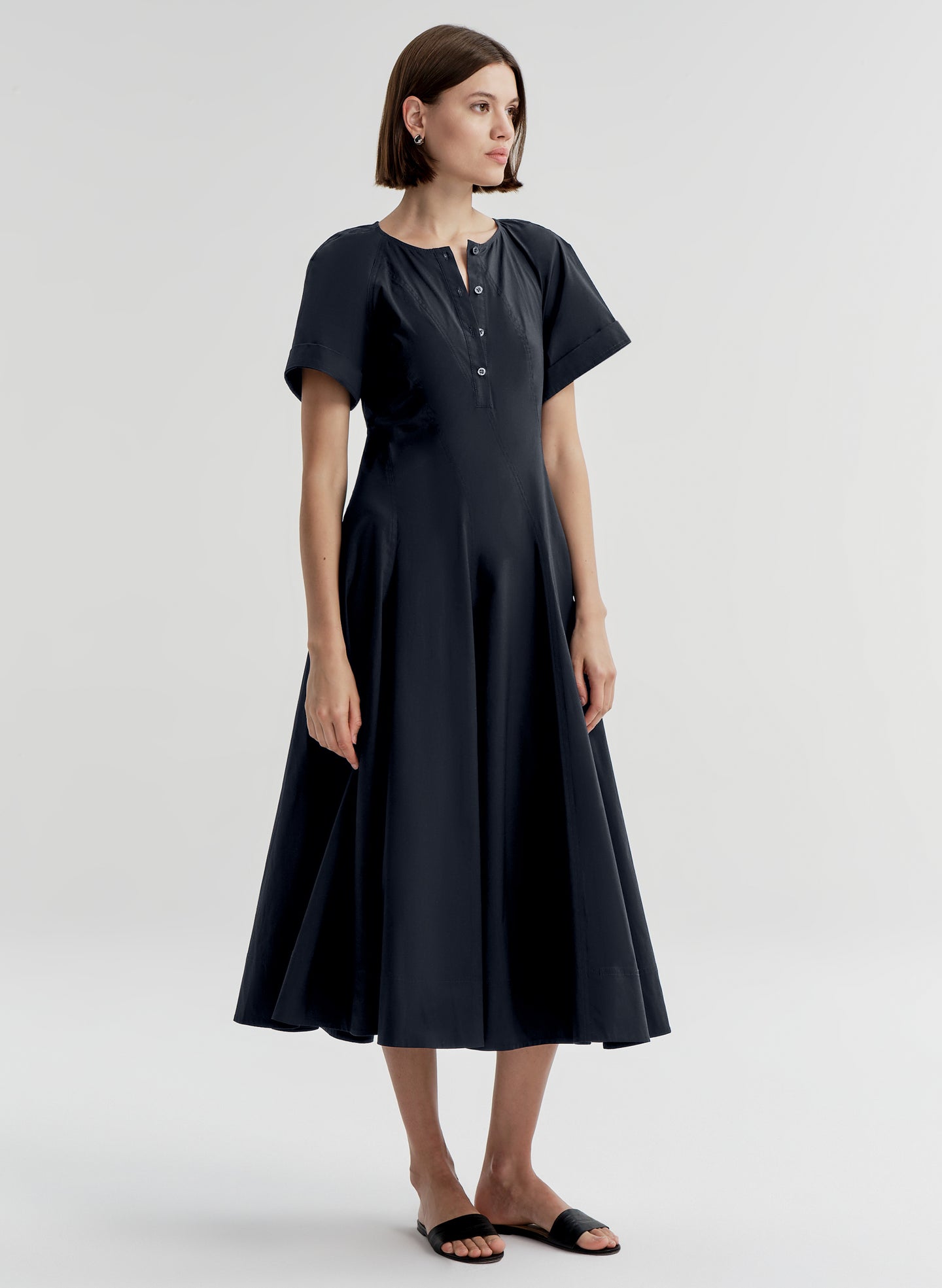Woman wearing a dark blue short sleeve dress on a white background
