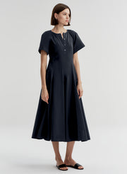 Woman wearing a dark blue short sleeve dress on a white background