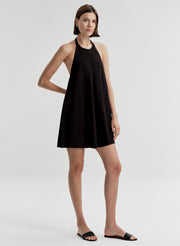 Woman wearing a black halter neck dress on a white background