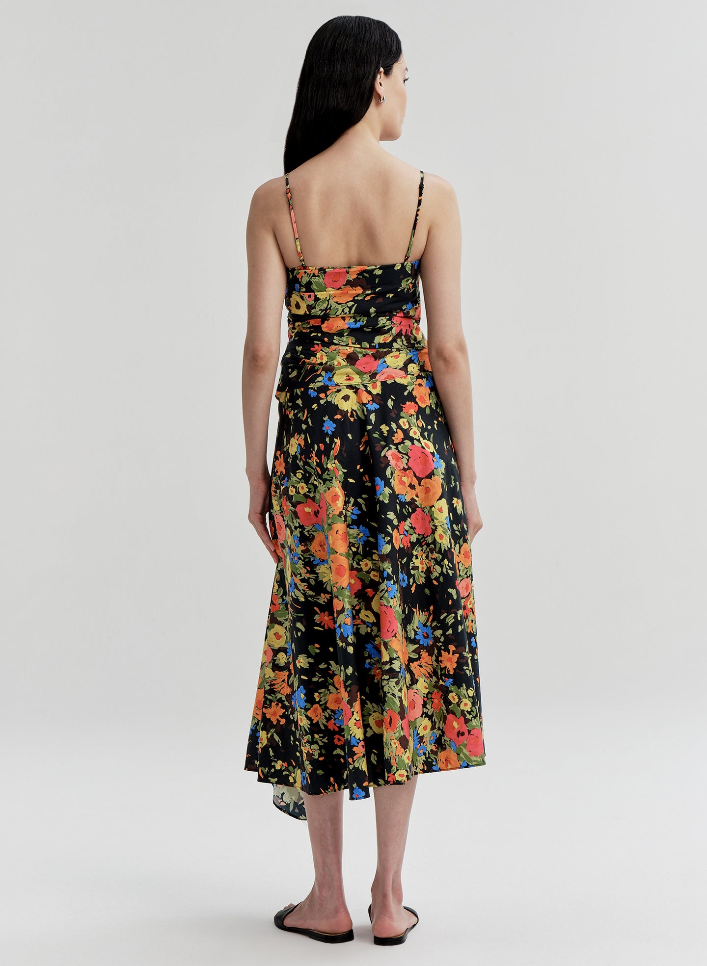Woman wearing a colorful floral dress on a white background