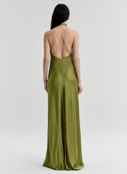 Woman wearing a green gown with a backless design on a white background