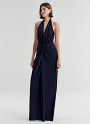 Woman wearing a navy blue halter neck gown on a white background