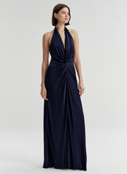 Woman wearing a navy blue halter neck gown on a white background