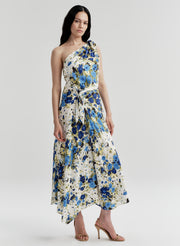 Woman wearing a floral one-shoulder dress on a plain background