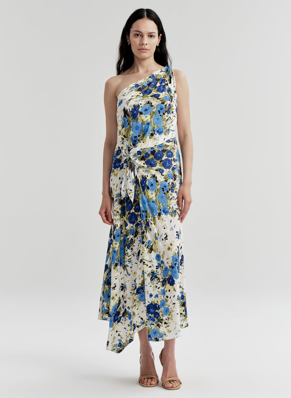 Woman wearing a floral one-shoulder dress on a plain background
