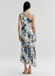 Woman wearing a floral one-shoulder dress on a plain background