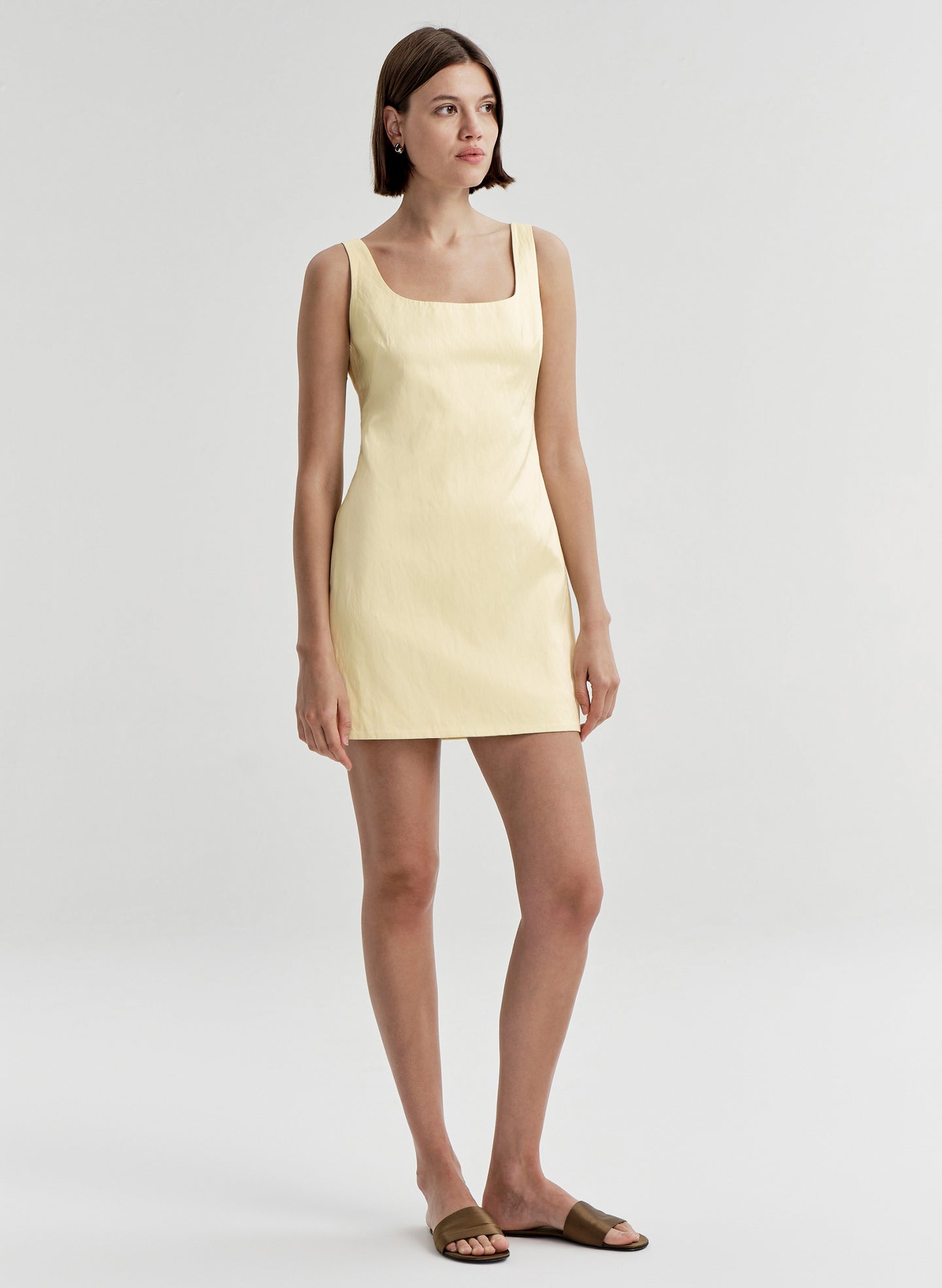 Woman wearing a light yellow dress on a white background