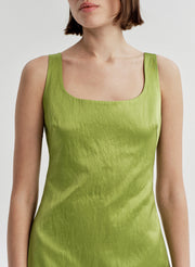 Woman wearing a green sleeveless dress on a white background