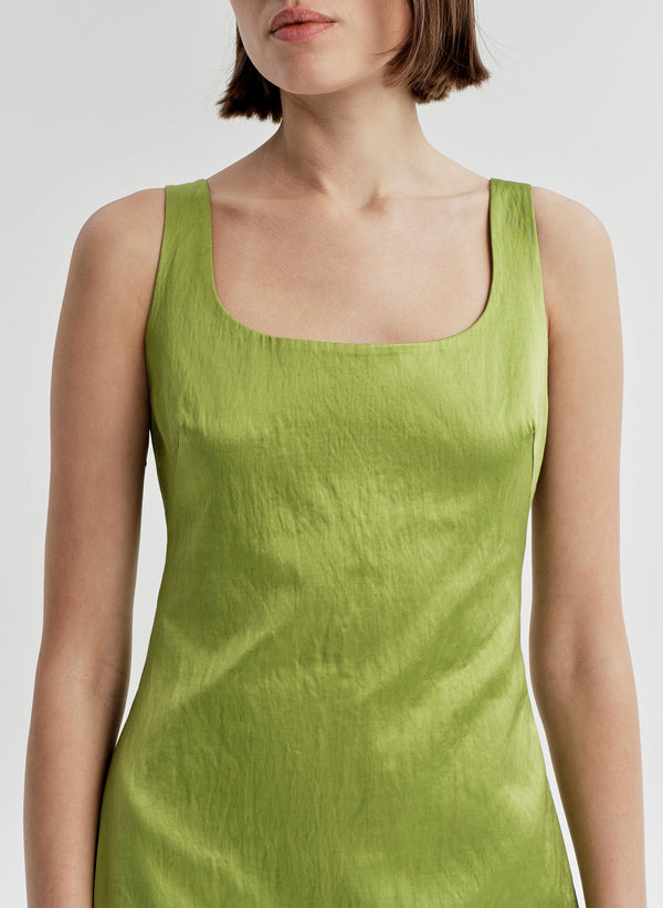 Woman wearing a green sleeveless dress on a white background