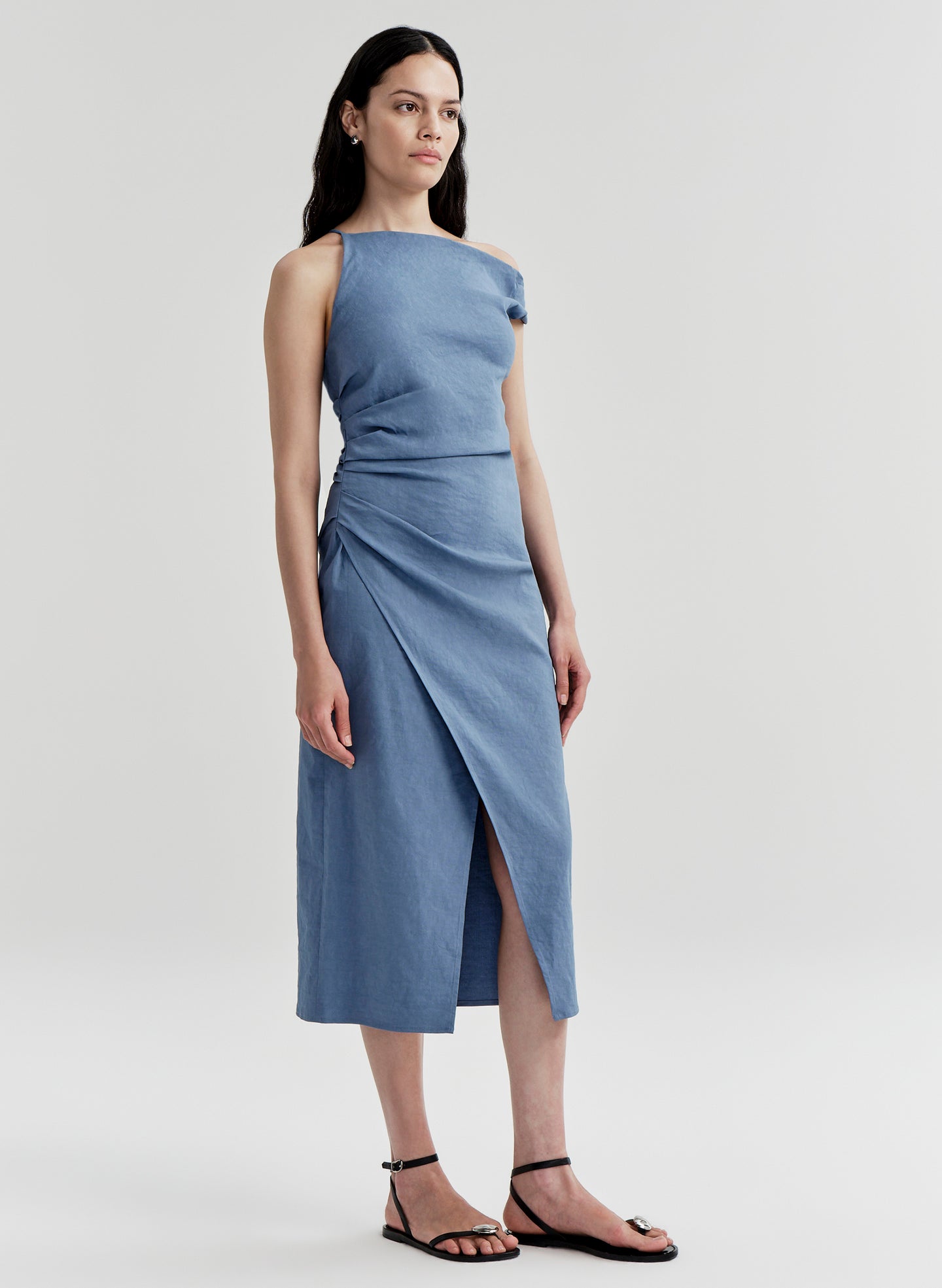 Woman wearing a blue one-shoulder dress on a light gray background